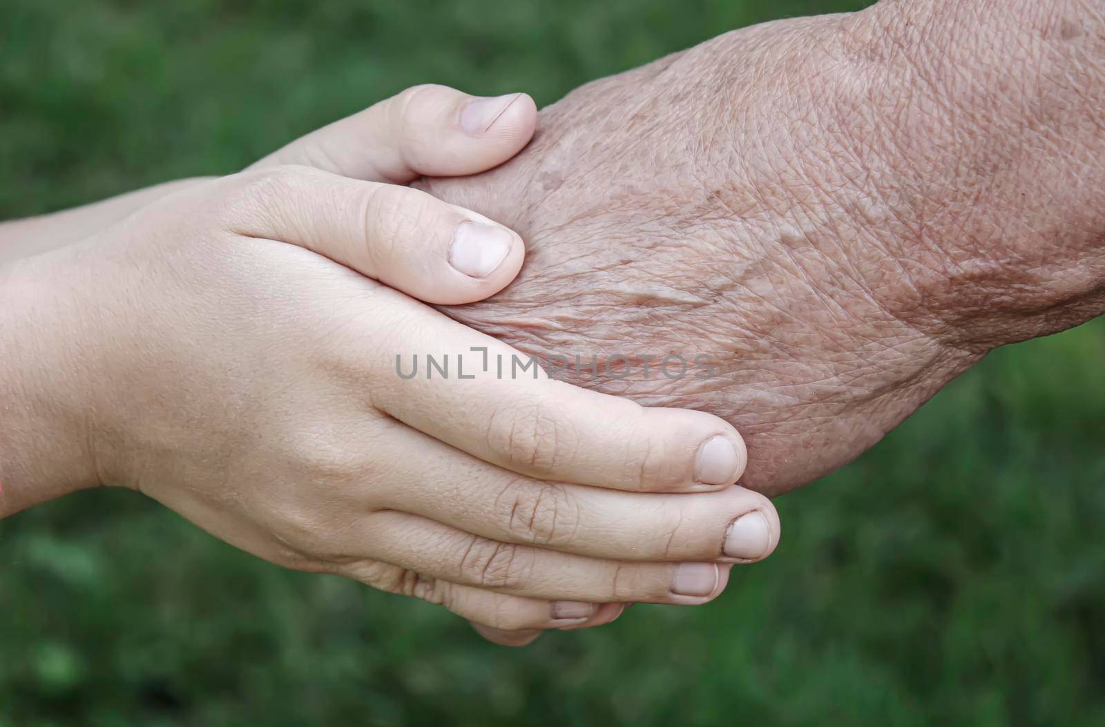 old man holding child's hands. selective focus people