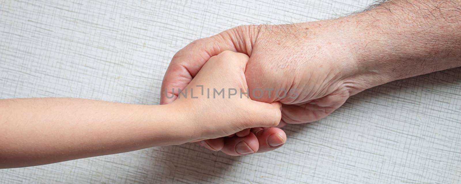 old man holding child's hands. selective focus people