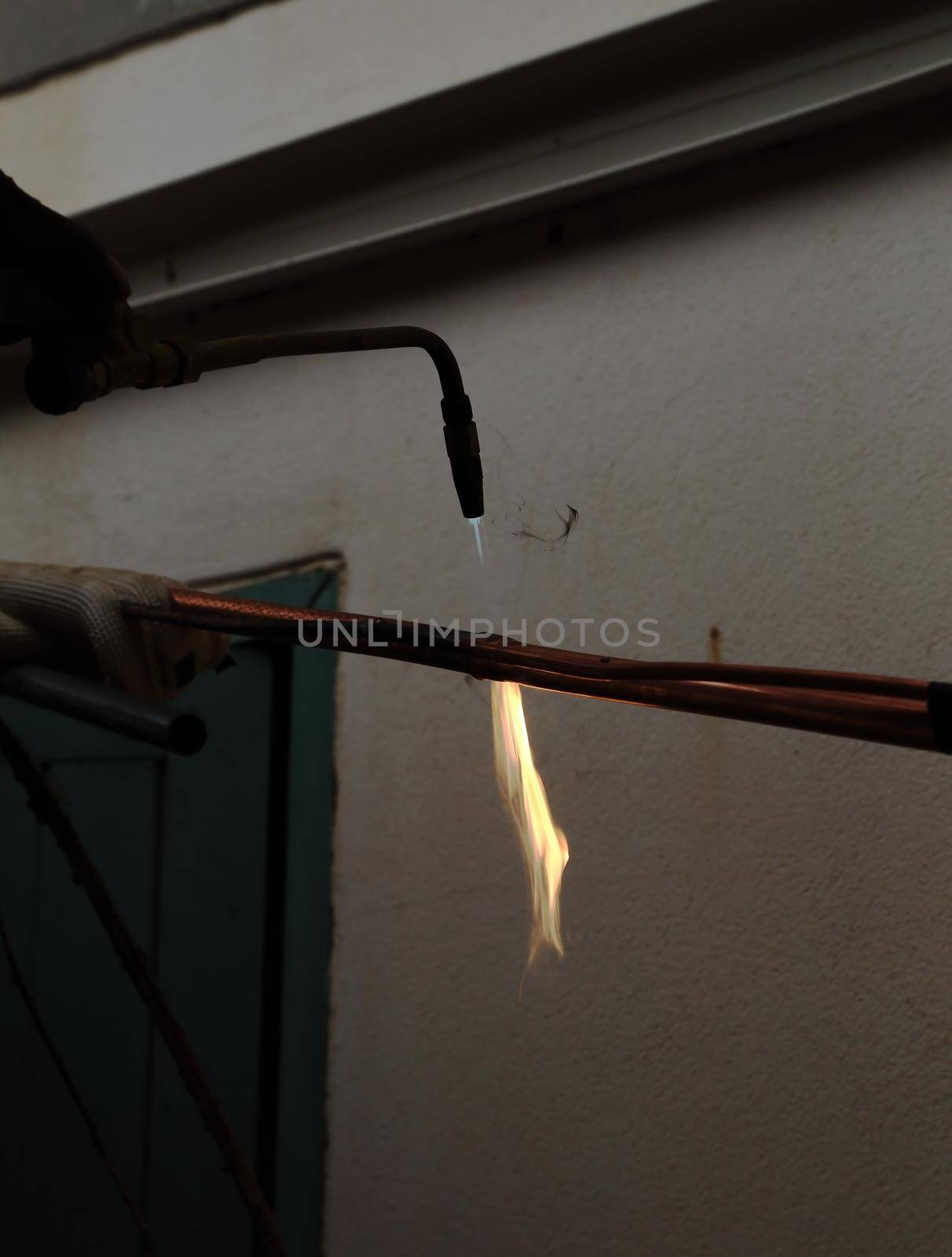 Air conditioner repairman welding copper pipes