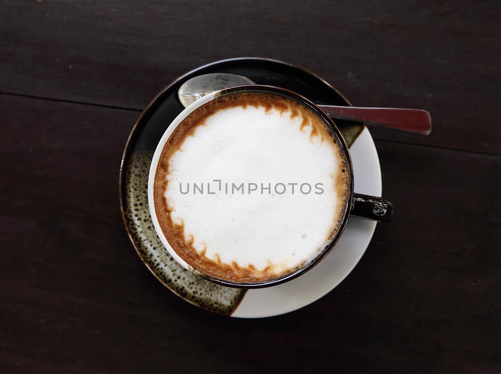 cup of hot coffee with cream on table