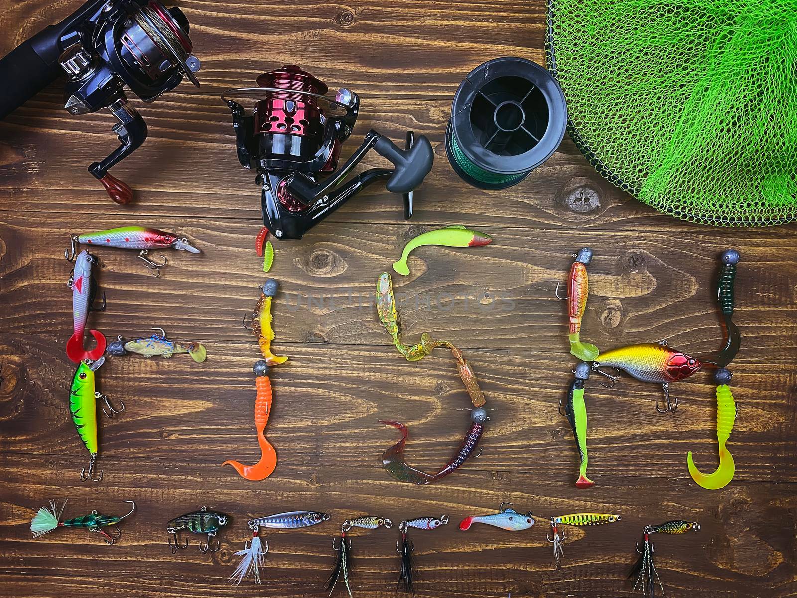Fishing tackle. Float, wobbler, bait hooks, on a wooden background. Selective focus