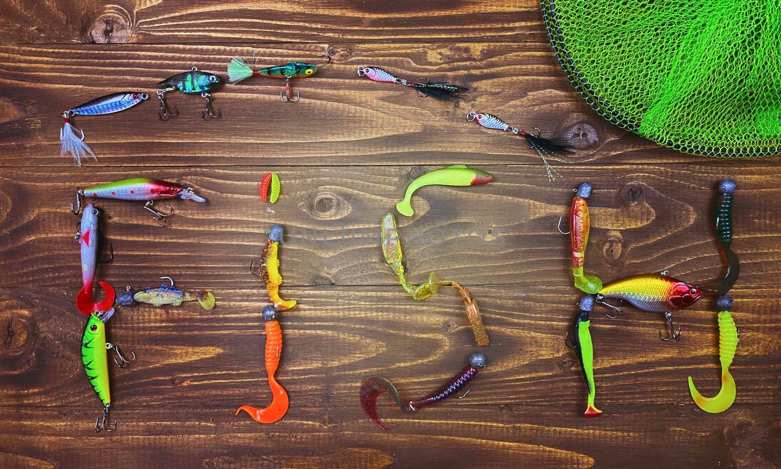 Fishing tackle. Float, wobbler, bait hooks, on a wooden background. Selective focus