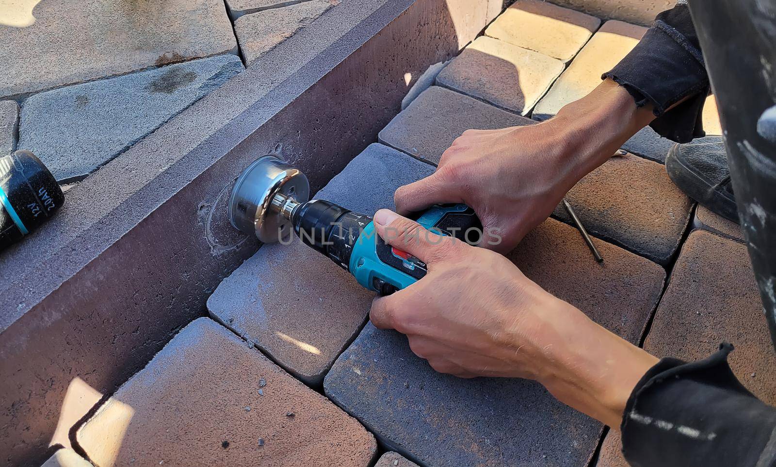 drilling a concrete curb to install the luminaire. Selective focus