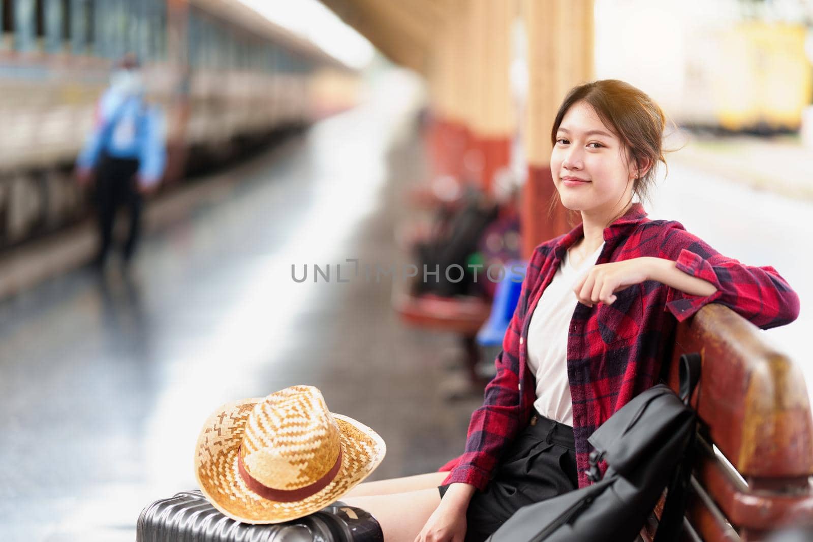 Young traveler woman looking for friend planning trip at train station. Summer and travel lifestyle concept