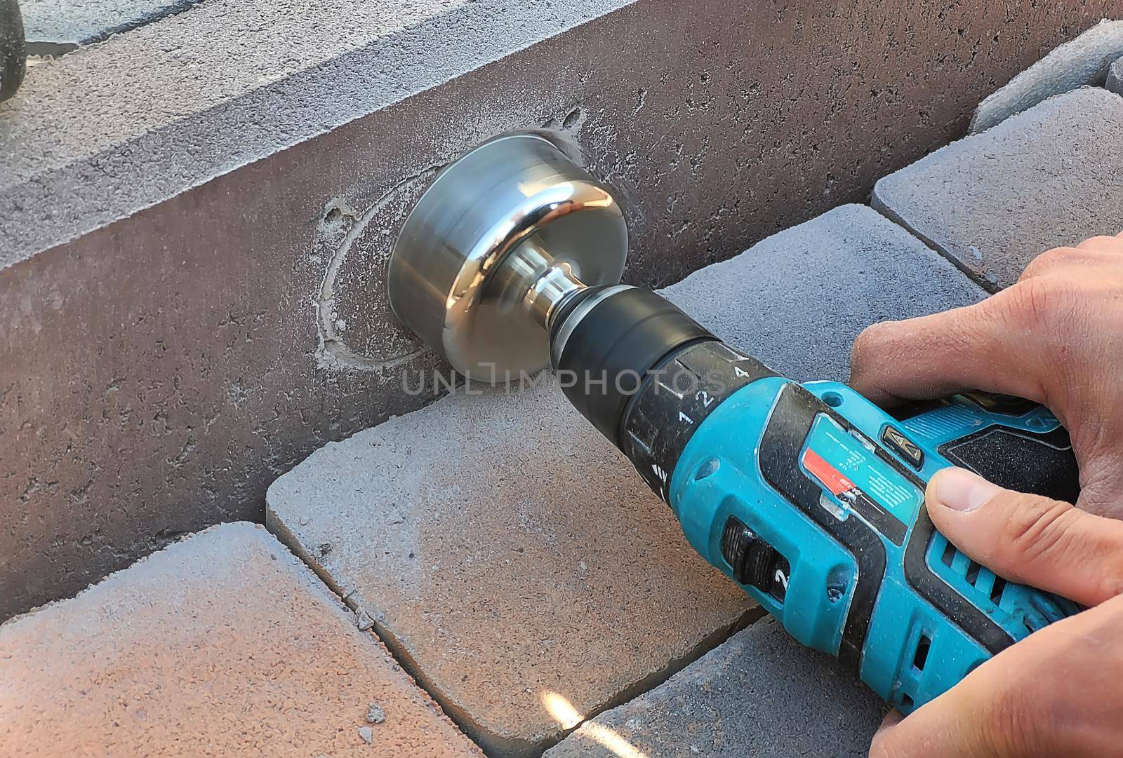 drilling a concrete curb to install the luminaire. Selective focus