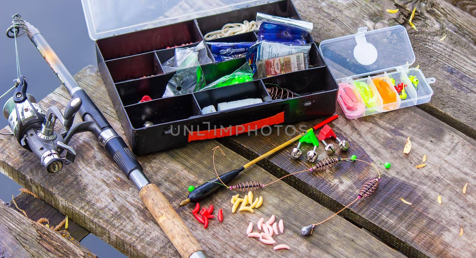 many colorful lures for fishing on the wooden pier. Selective focus. nature