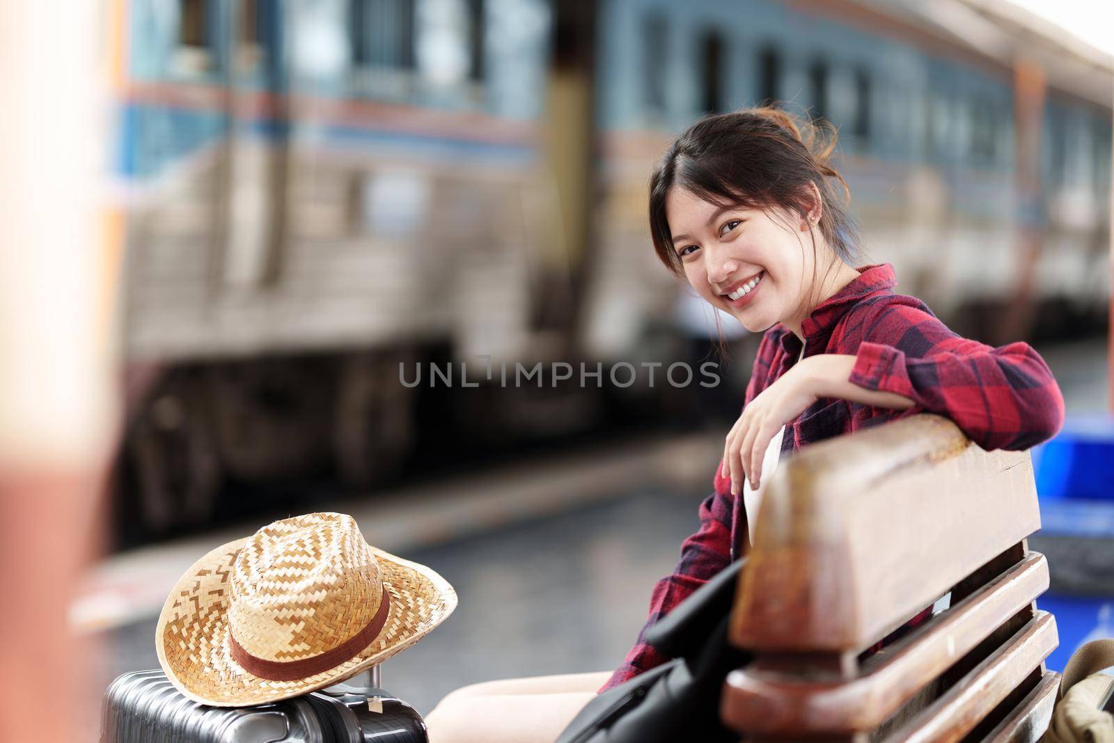 Pretty Young traveler woman planning trip at train station. Summer and travel lifestyle concept