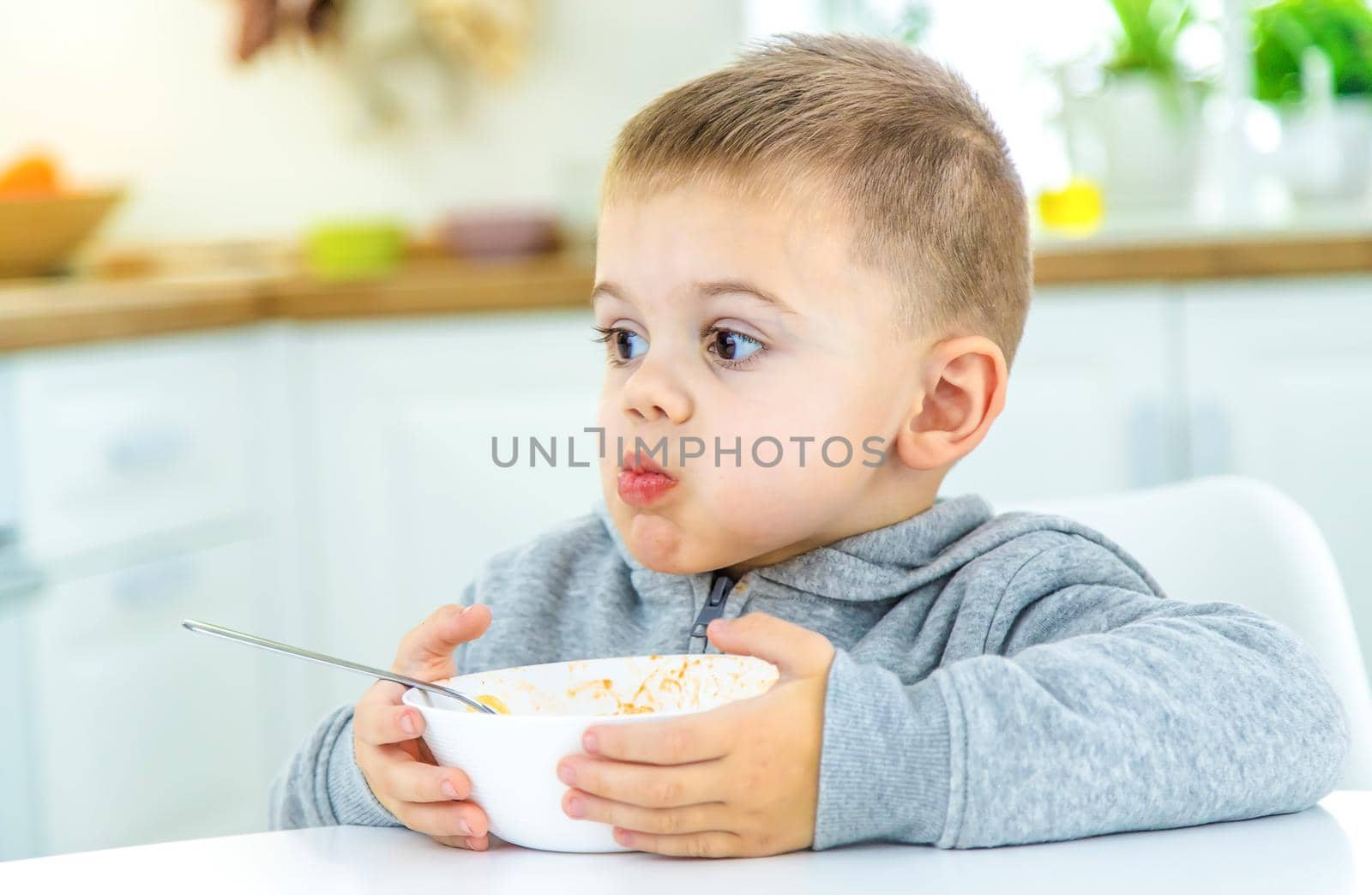 children in the kitchen at the table turning pasta. selective focus