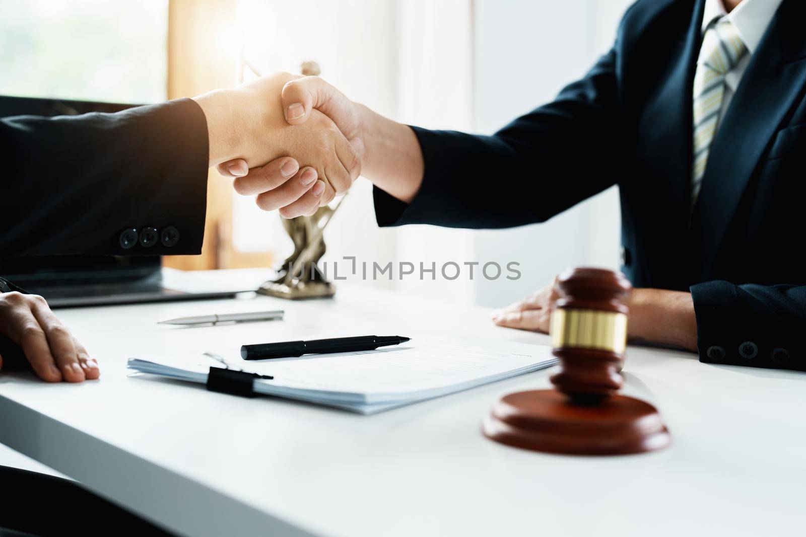 Law, consultation, agreement, contract, lawyer or attorney shakes hands to agree on the client's offer to be hired to fight the parties in court