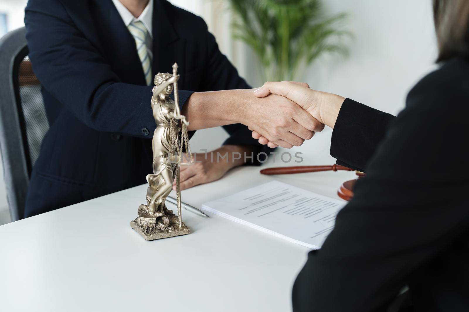 Law, consultation, agreement, contract, lawyer or attorney shakes hands to agree on the client's offer to be hired to fight the parties in court. by Manastrong