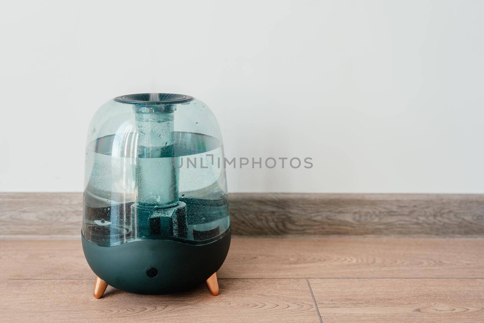 Modern air humidifier on a white wall background. Humidifier spreading steam into the living room by driver-s