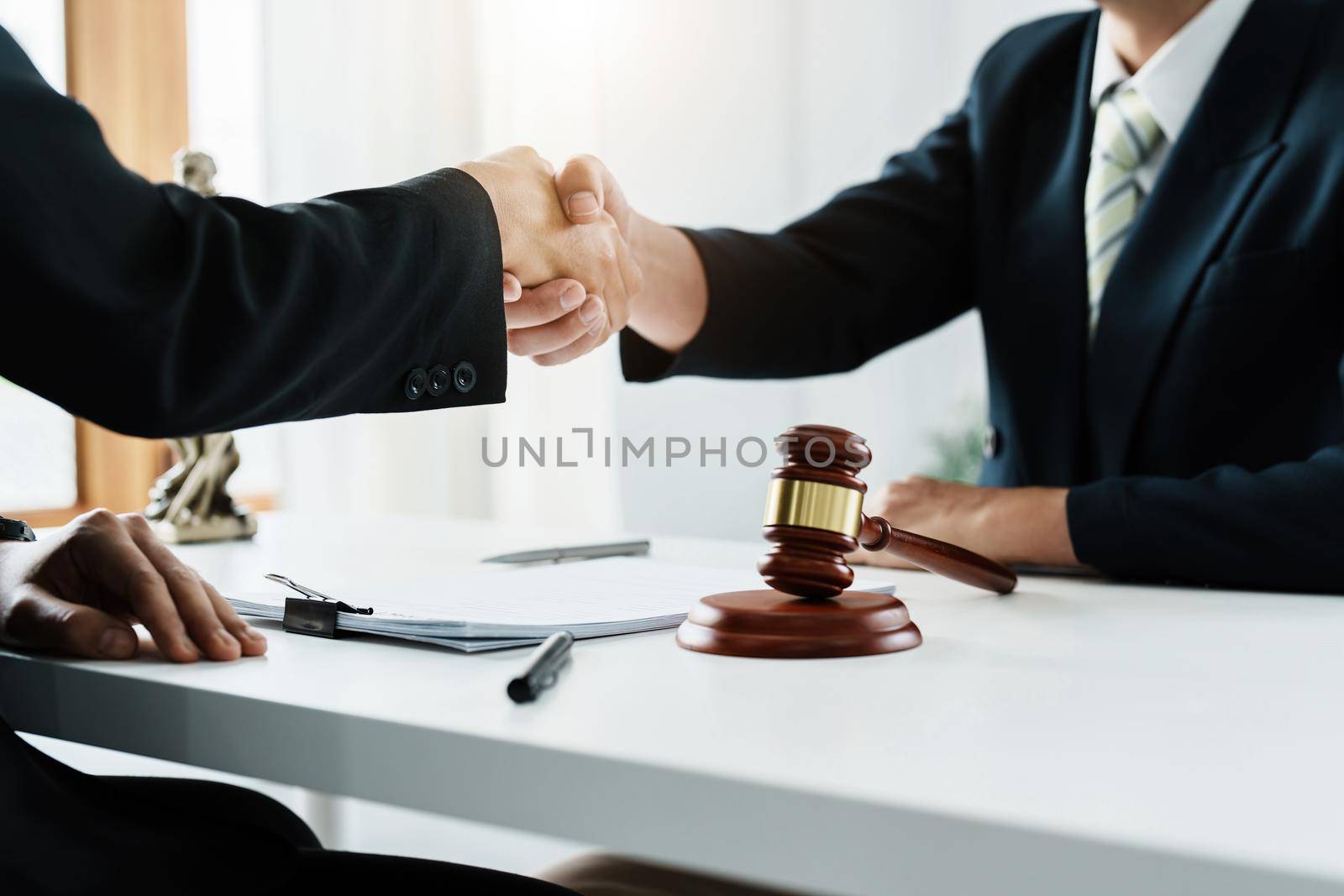Law, consultation, agreement, contract, lawyer or attorney shakes hands to agree on the client's offer to be hired to fight the parties in court