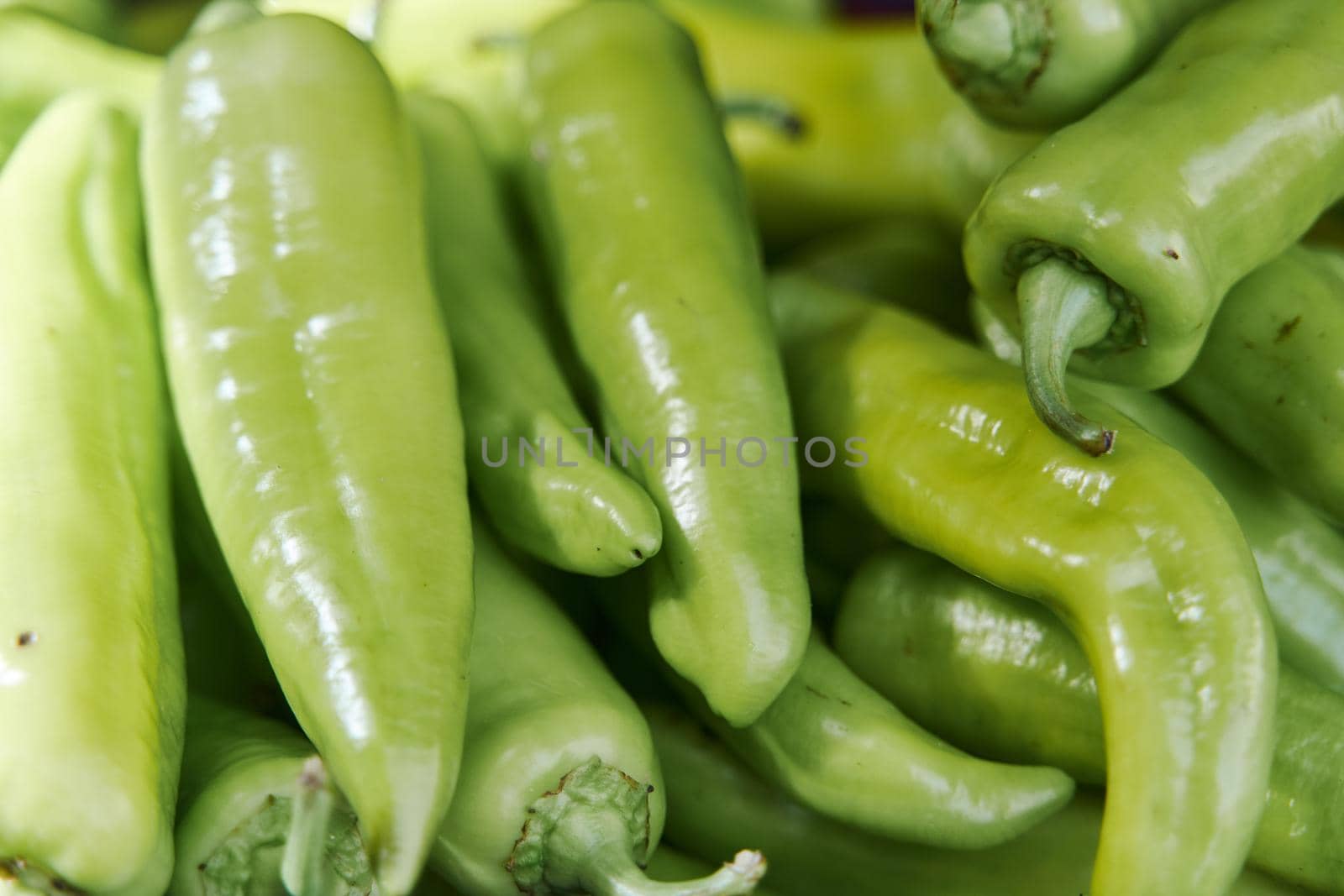 Green fresh peppers on the counter in a vegetable shop. High quality photo