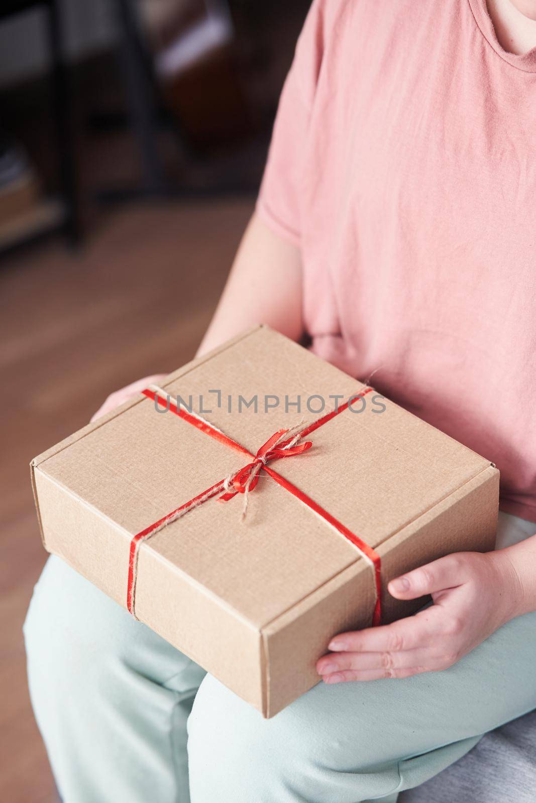 Selected focus. Girl holding a gift box with a red ribbon in her hands by driver-s
