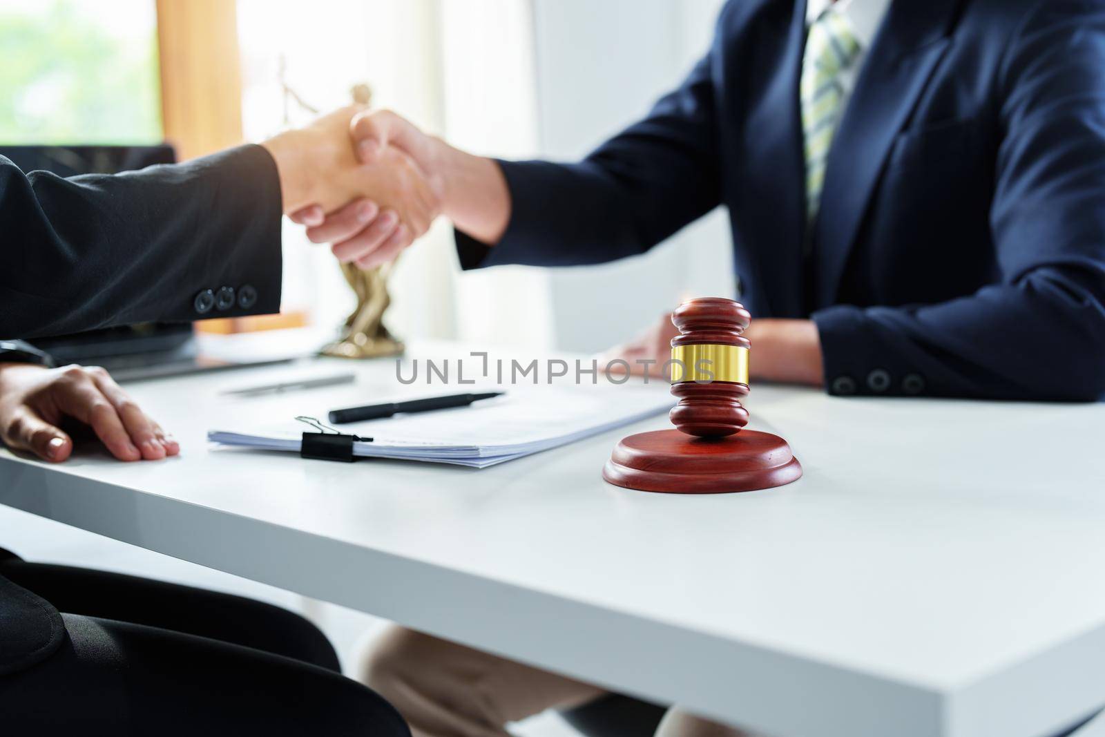 Law, consultation, agreement, contract, lawyer or attorney shakes hands to agree on the client's offer to be hired to fight the parties in court. by Manastrong