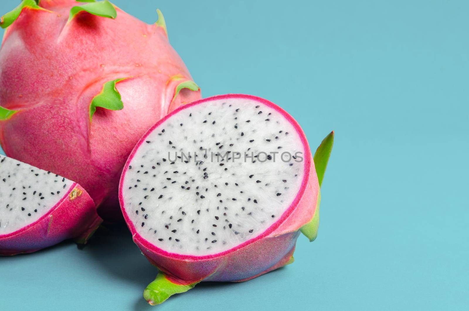The Halves of Fresh organic Dragon Fruit on a blue background.