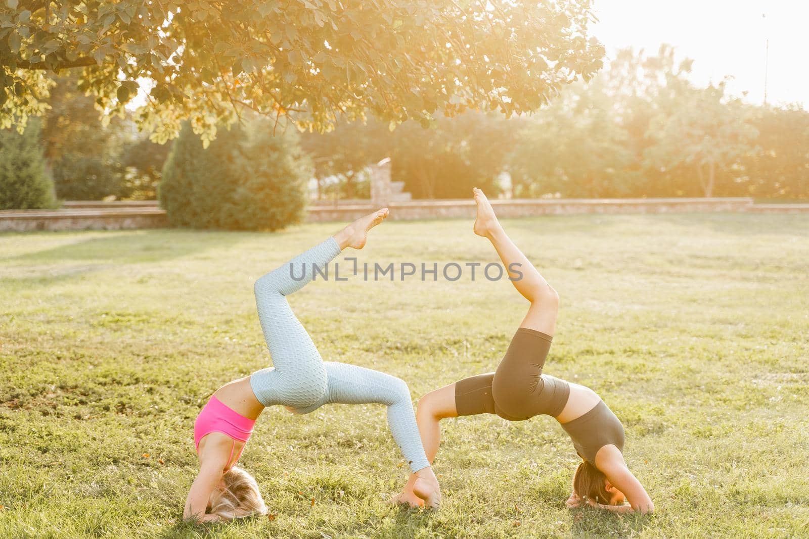 Gymnastics sport training outdoor. 2 Girls do sport exercises in the park. Sport lifestyle. by Rabizo