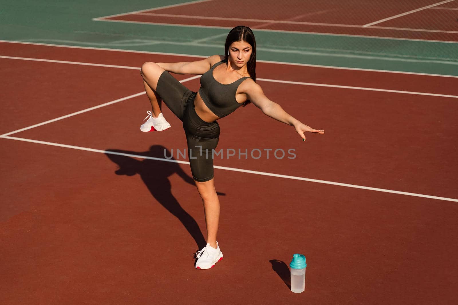 Fit girl does warm-up and stretching exercises before a street workout. Sports lifestyle