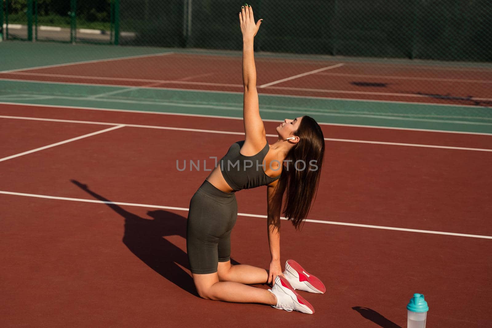 Fit girl does warm-up and stretching exercises before a street workout. Sports lifestyle