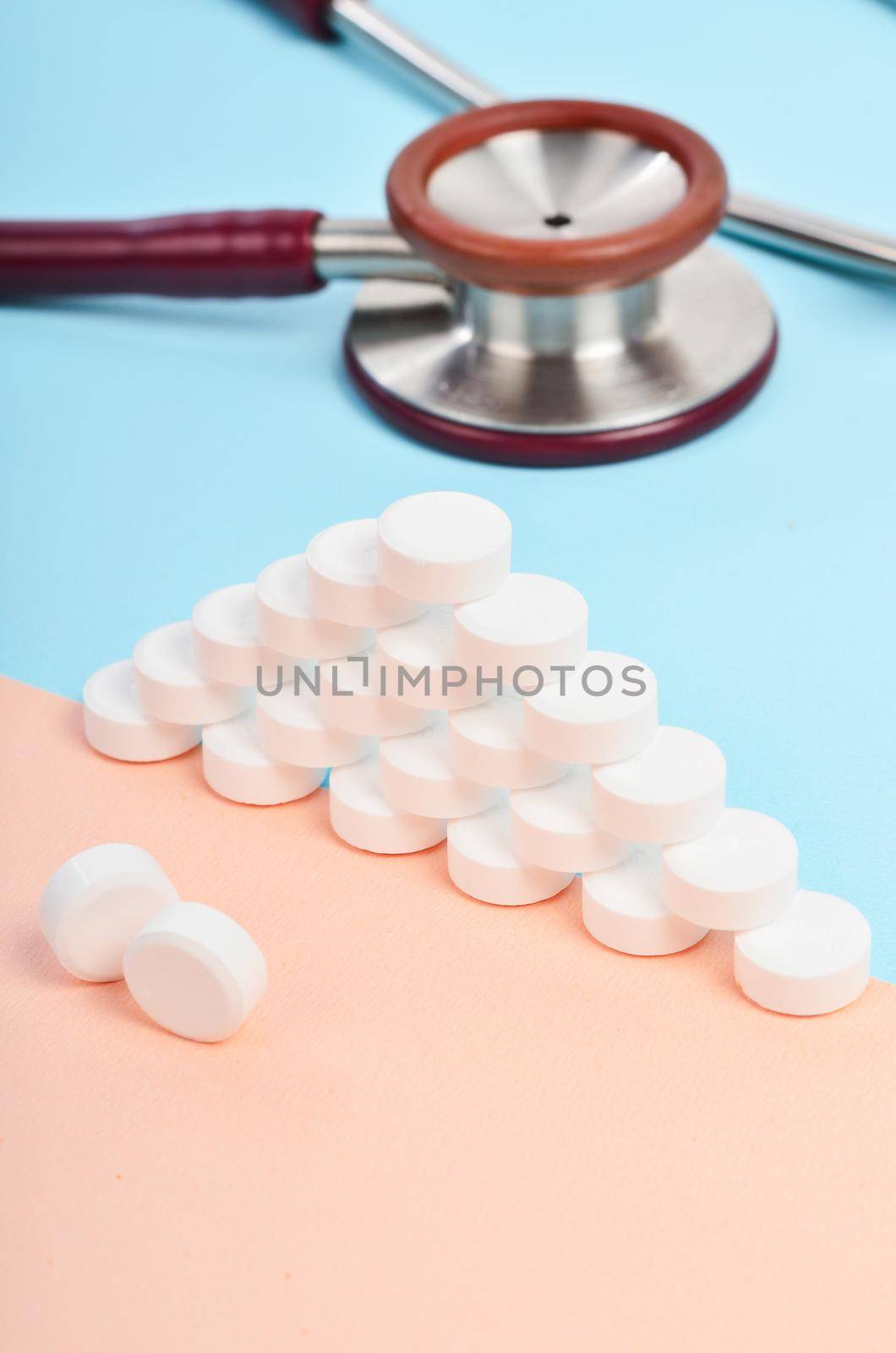 The White tablet medicine with medicine stethoscope on blue background.
