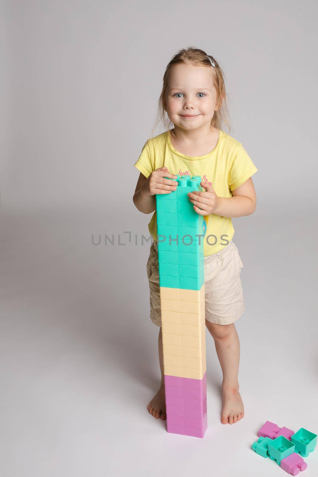 Adorable little kid playing with colorful blocks. by StudioLucky