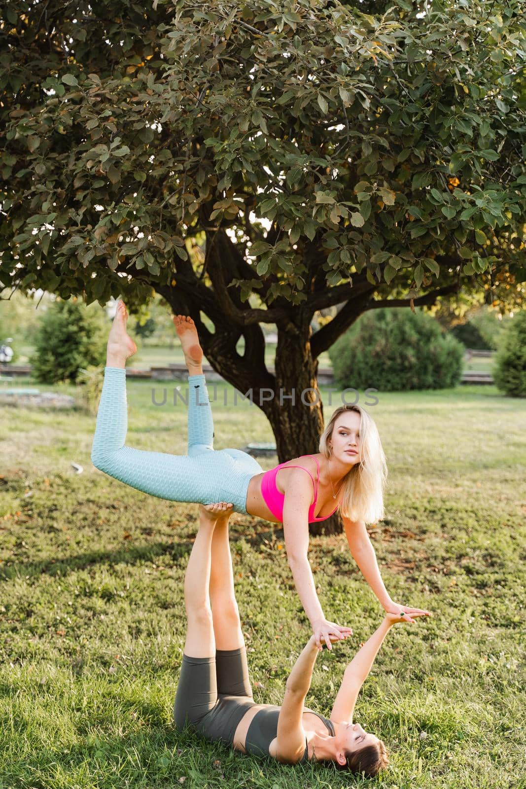 Gymnastics sport training outdoor. 2 Girls do sport exercises in the park. Sport lifestyle