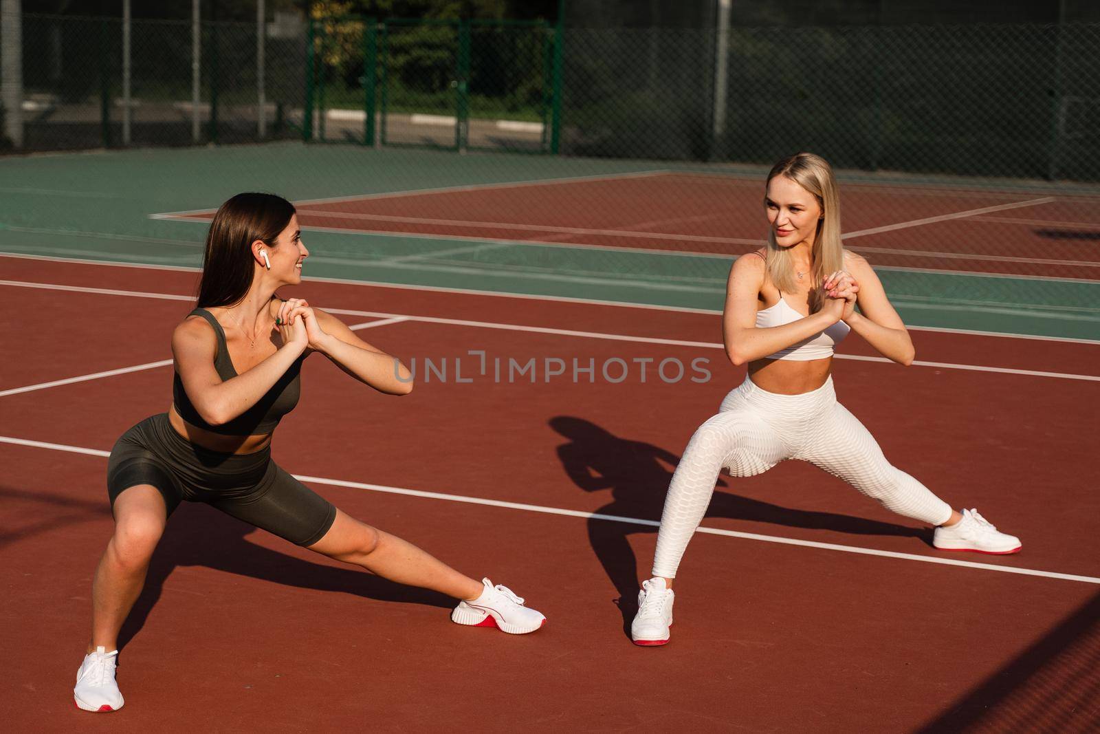 Group sport training of 2 girls. Active sport lifestyle. Outdoor training by Rabizo
