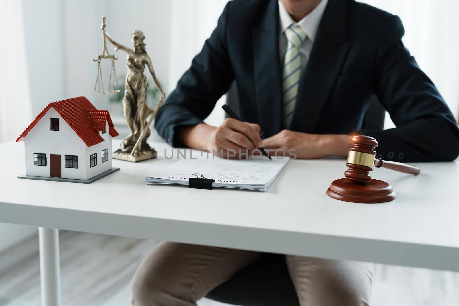 Law, Consultation, Agreement, Contract, Concept Attorney or lawyer focusing on the court hammer is sitting on the chair with a client's complaint to determine the house and land in court by Manastrong