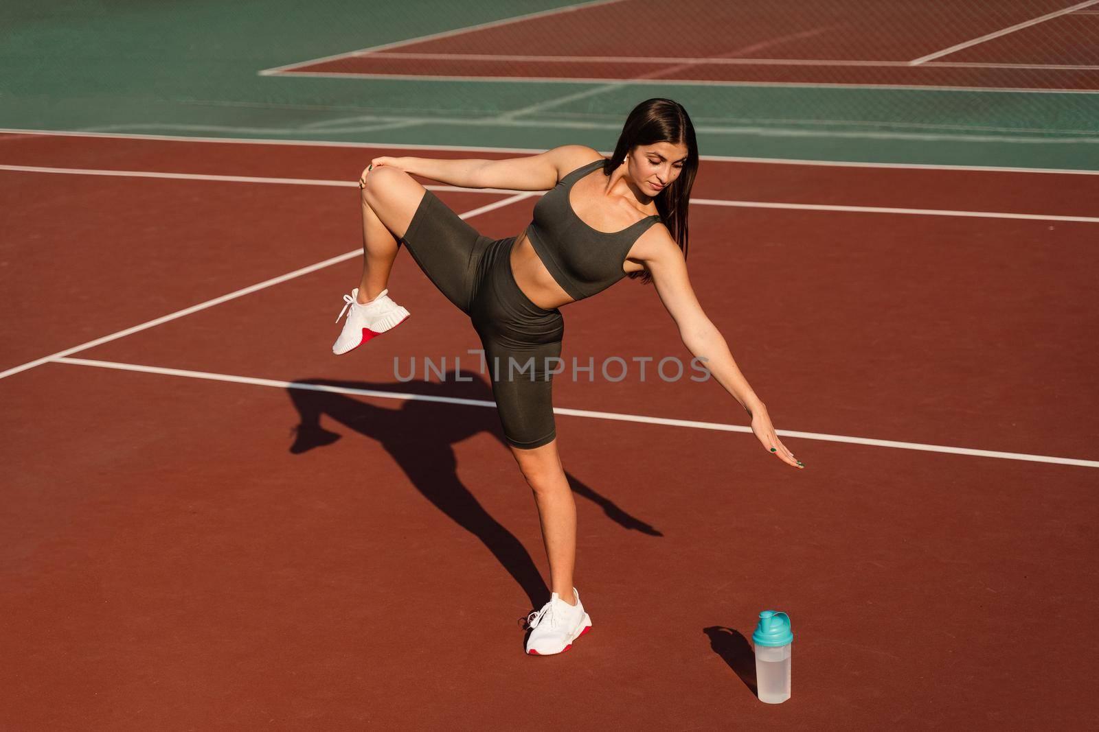 Warm-up and stretching before street workout. Attractive asian girl training on the tennis court