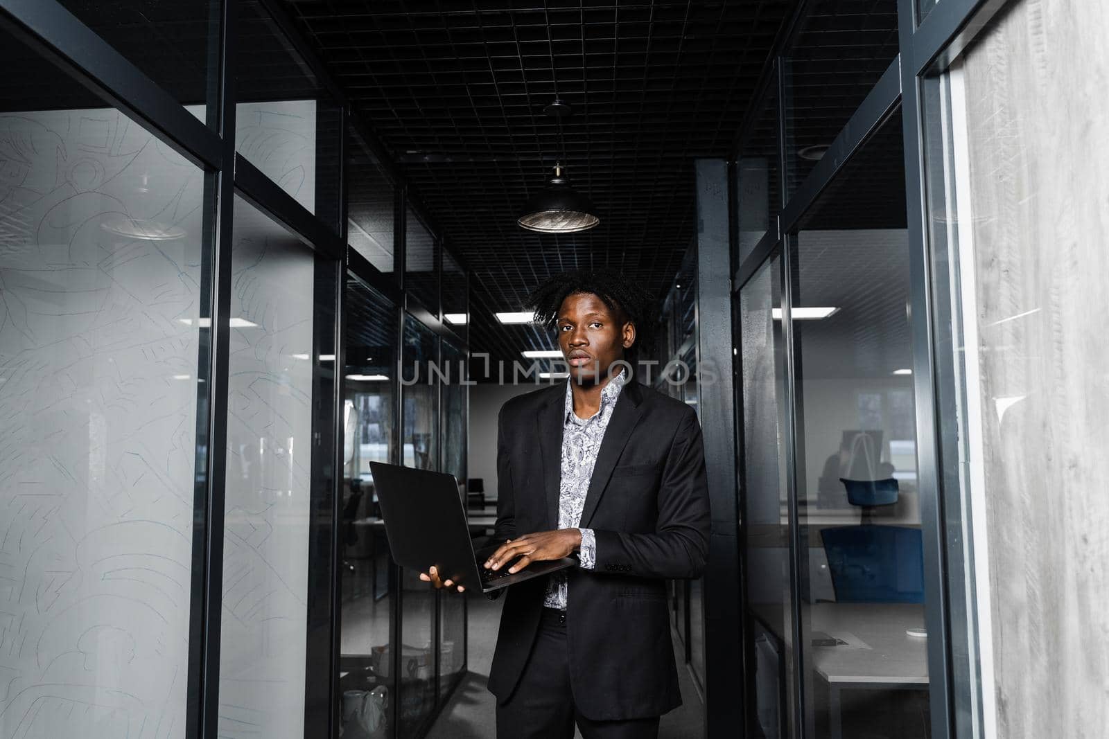 Black man freelancer with laptop in coworking space. Online working on laptop