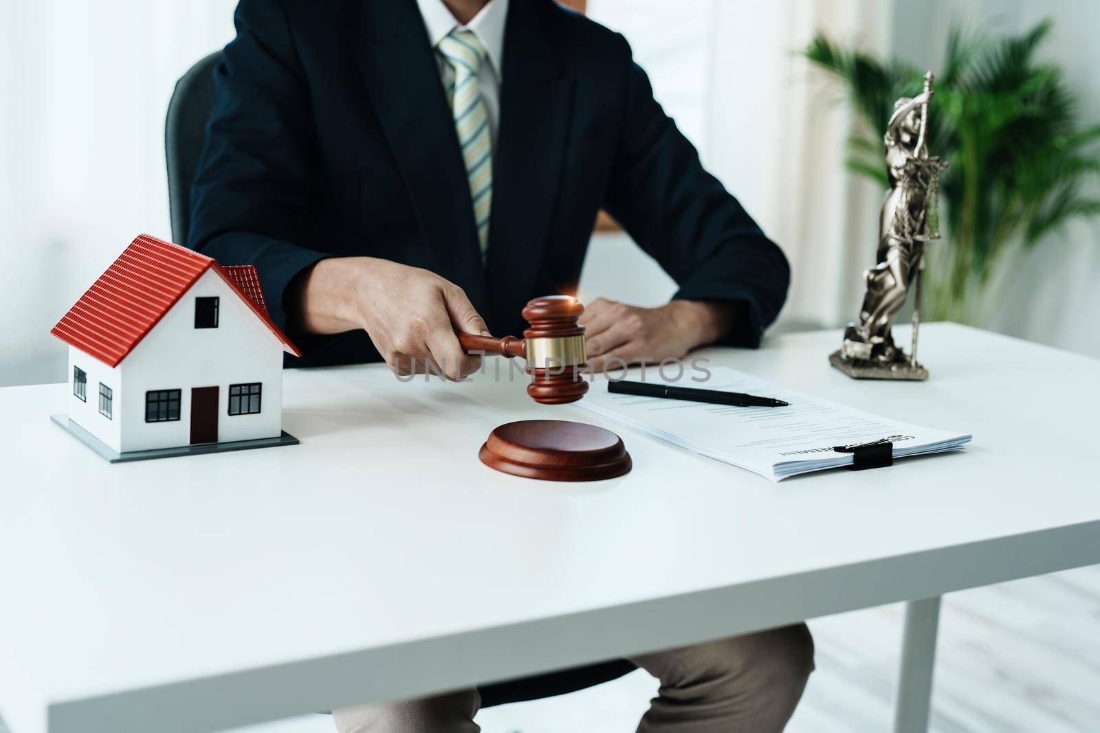 Law, Consultation, Agreement, Contract, Concept Attorney or lawyer focusing on the court hammer is sitting on the chair with a client's complaint to determine the house and land in court.