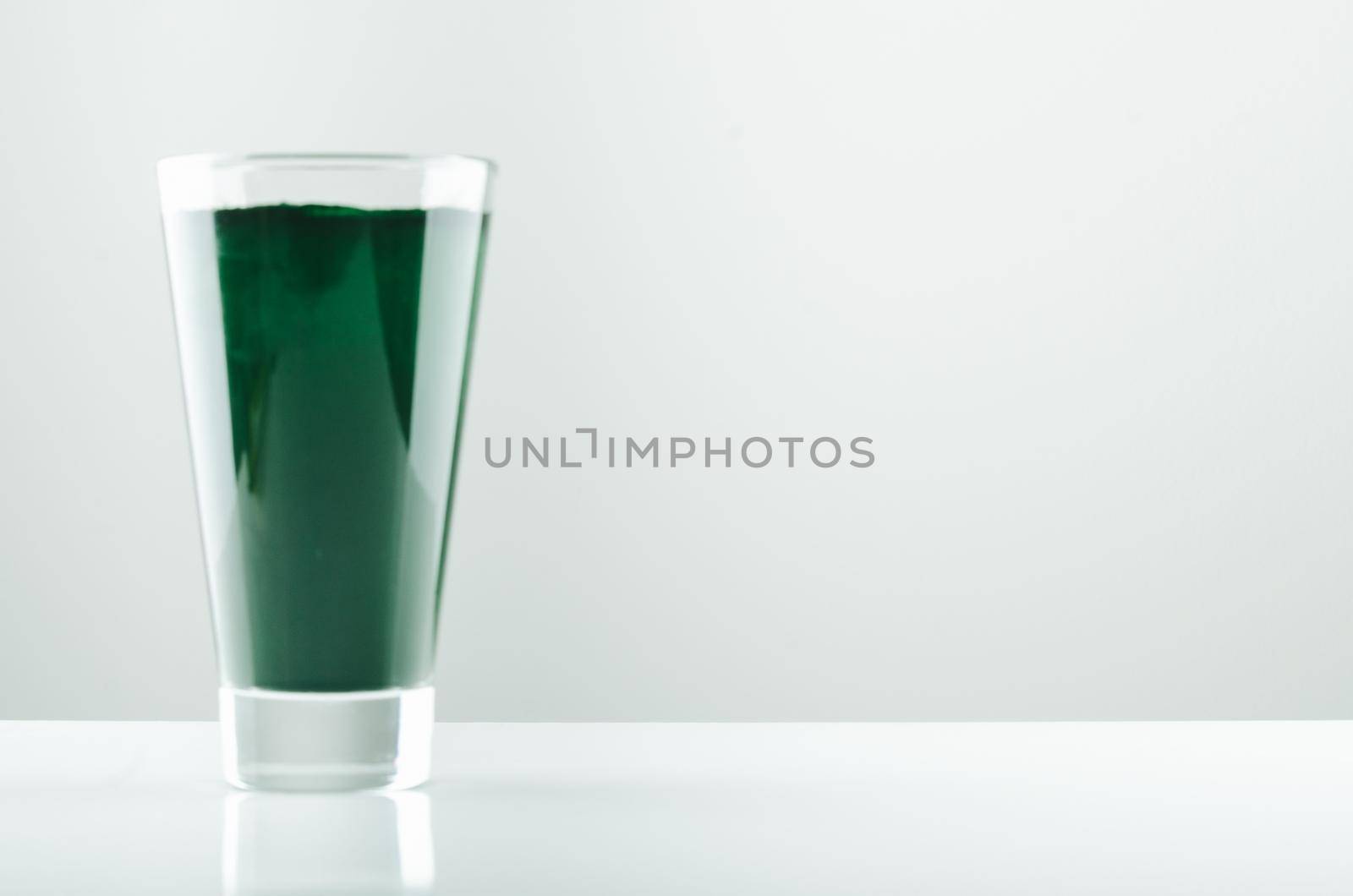 minimalist glass with water and spirulina powder. High quality photo