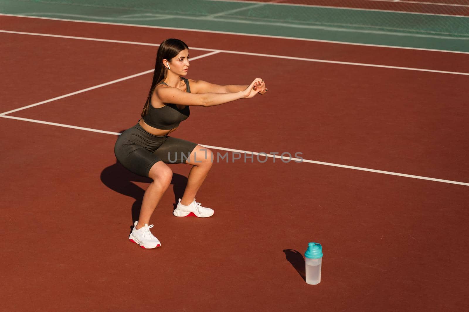 Fit athletic girl sit ups outdoors. Active lifestyle of a young Asian woman