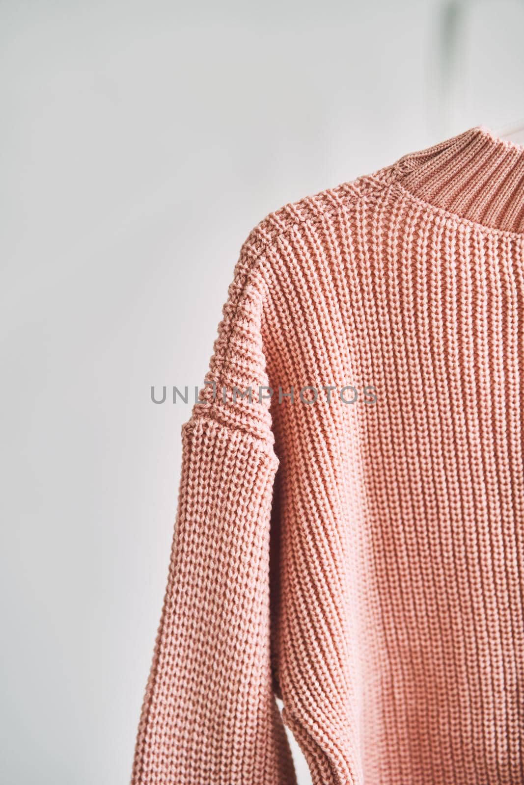 A woolen sweater hanging on a hanger on a white background. Warm clothes sale. Concept - everything is sold out in a clothing store.