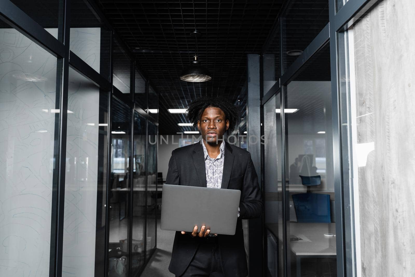 Black man freelancer with laptop in coworking space. Online working on laptop