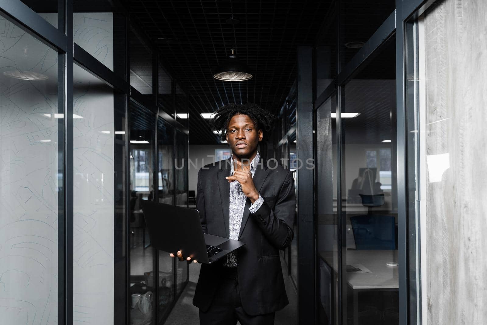 Confident black man freelancer with laptop in coworking space. Online working on laptop