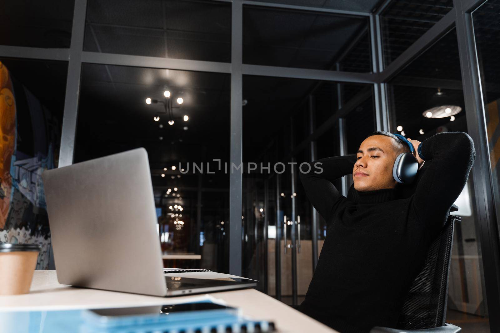 Sleepy and tired asian man working overtime at laptop in office and taking break.