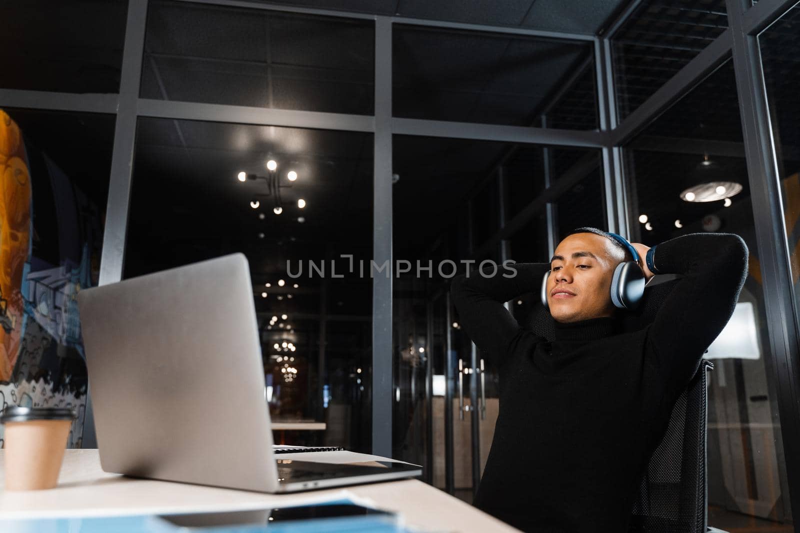 Sleepy and tired asian man working overtime at laptop in office and taking break. by Rabizo