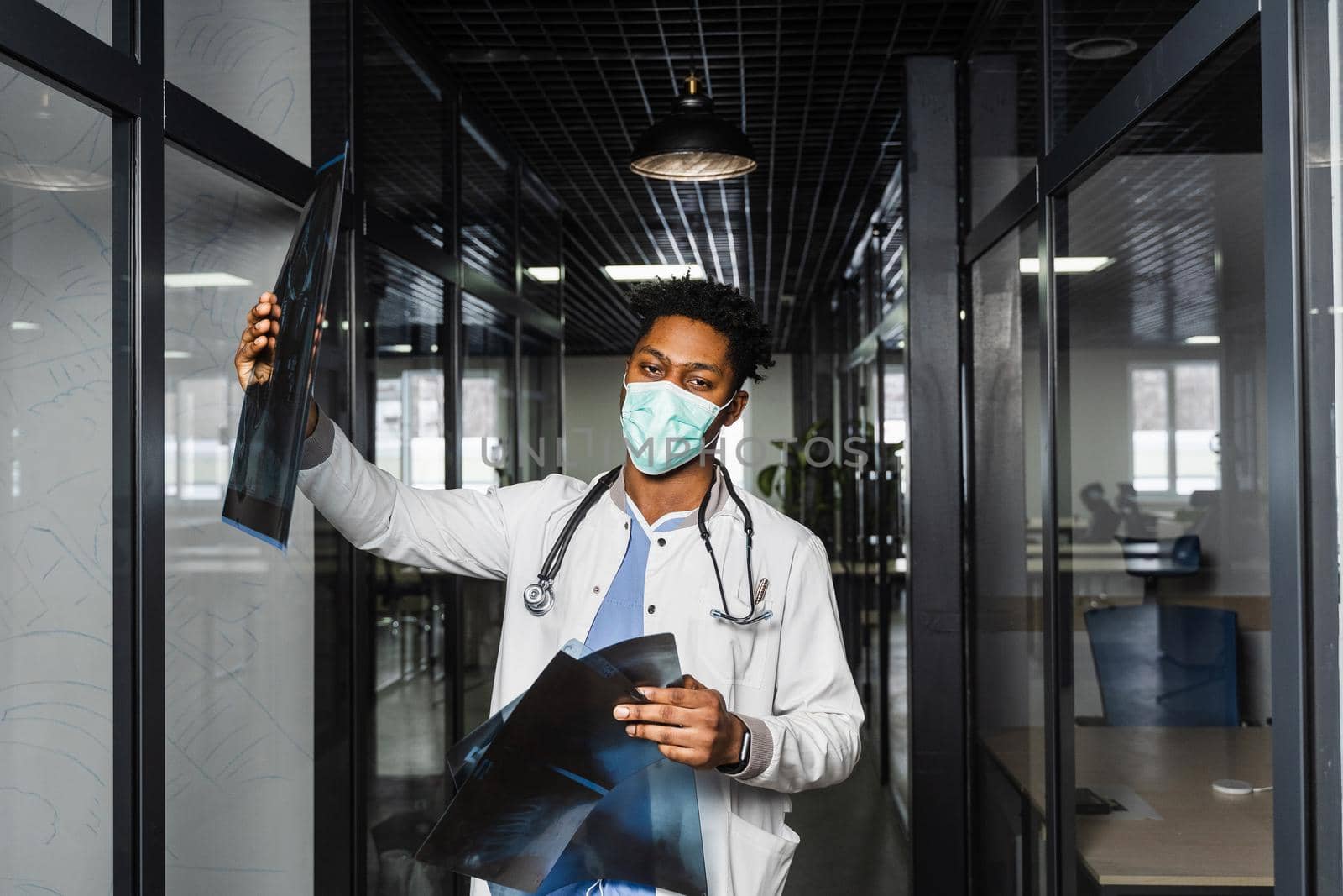 African doctor with x-ray scan in medical clinic. Black medical student in medical mask study in university