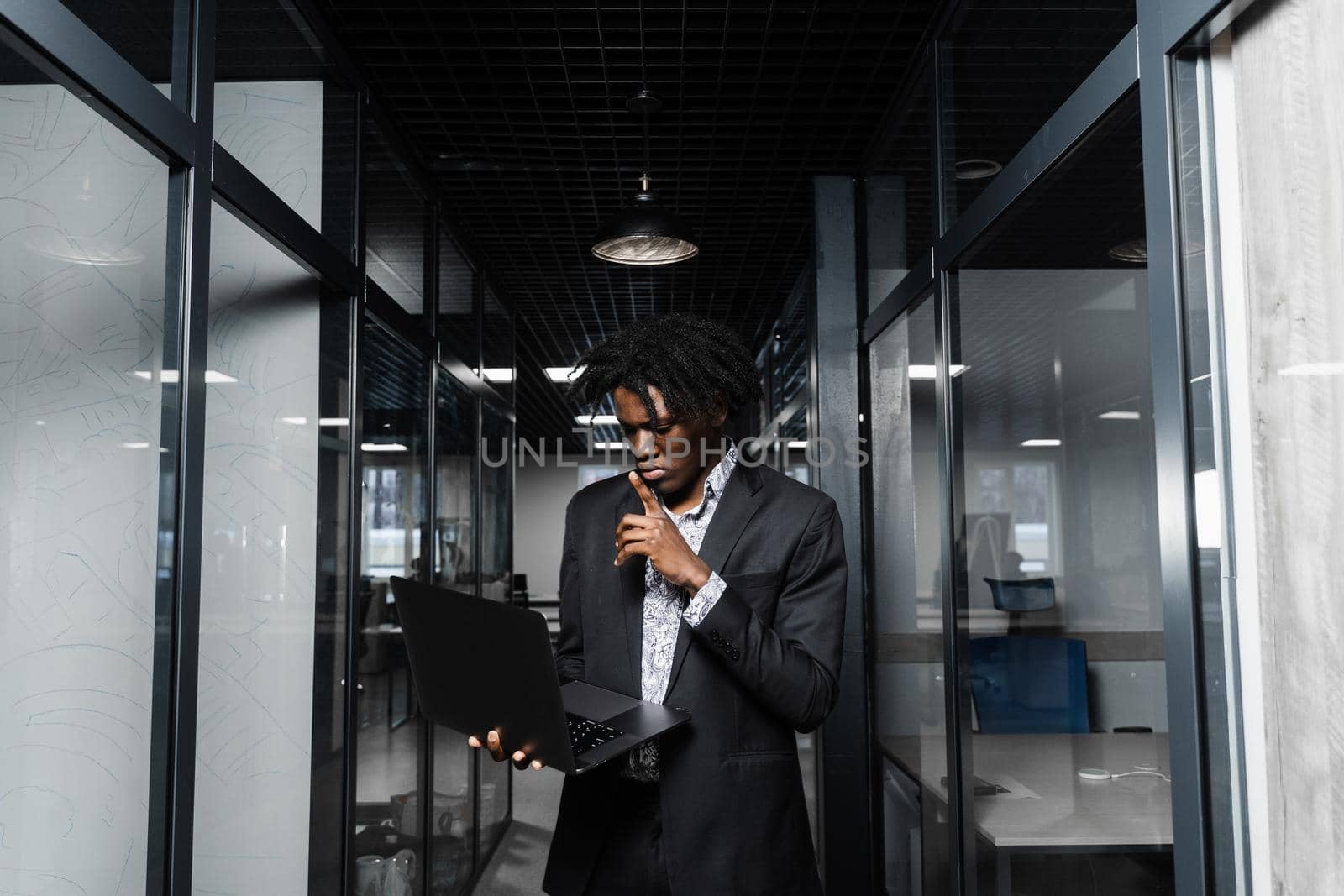 Confident black man freelancer with laptop in coworking space. Online working on laptop