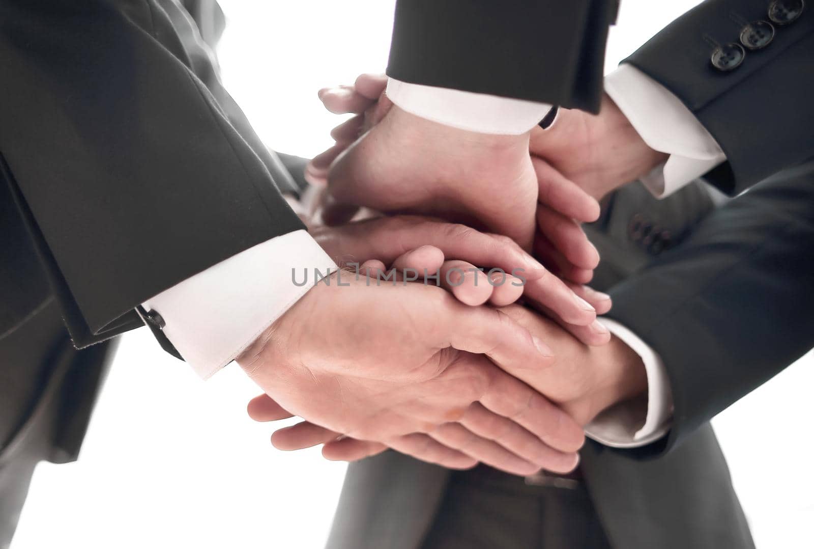 Close-up of businesspeople stacking hands in meeting. concept of unity