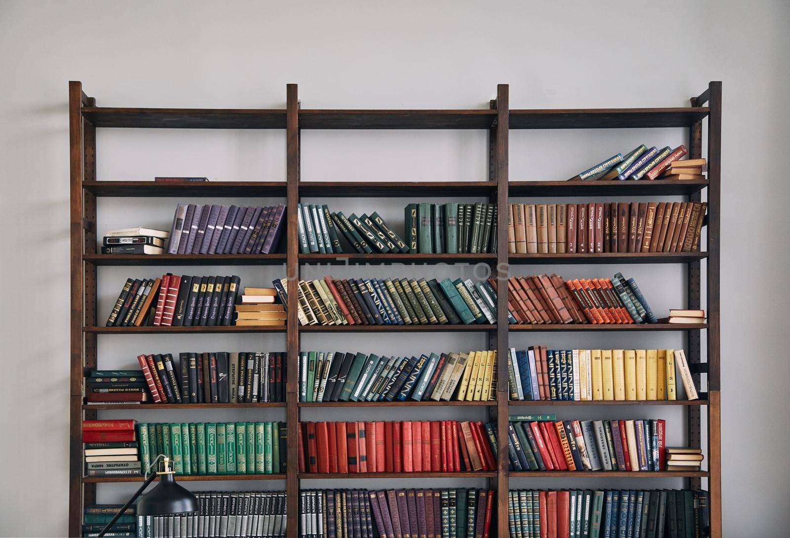 Bookcase with old books on the shelves. Books in an old wooden Cabinet