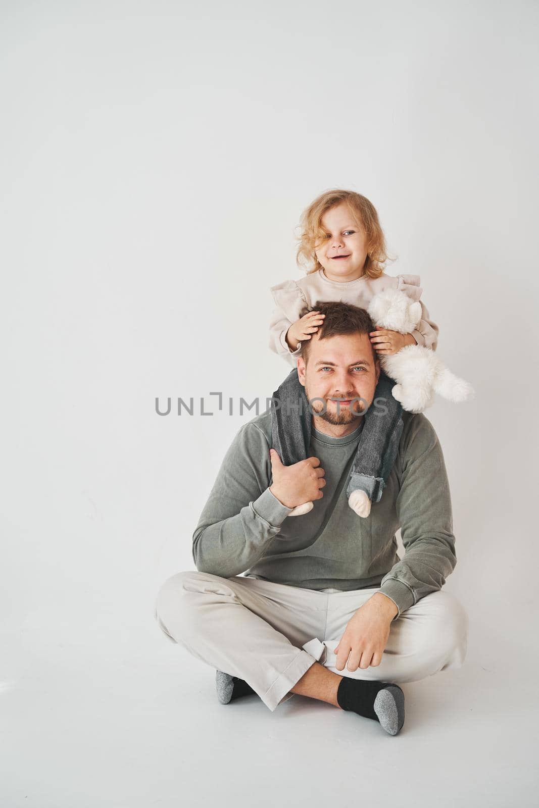 Happy family. Father and daughtersmile and have fun together on white background. by Rabizo