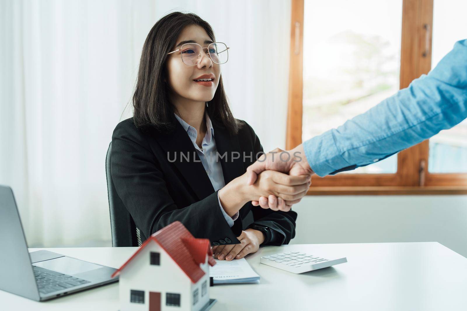 Laws, contracts, mortgages, clients join hands with real estate agents congratulating real estate agents on home and land purchase agreements with insurance to reduce risks during home installments.