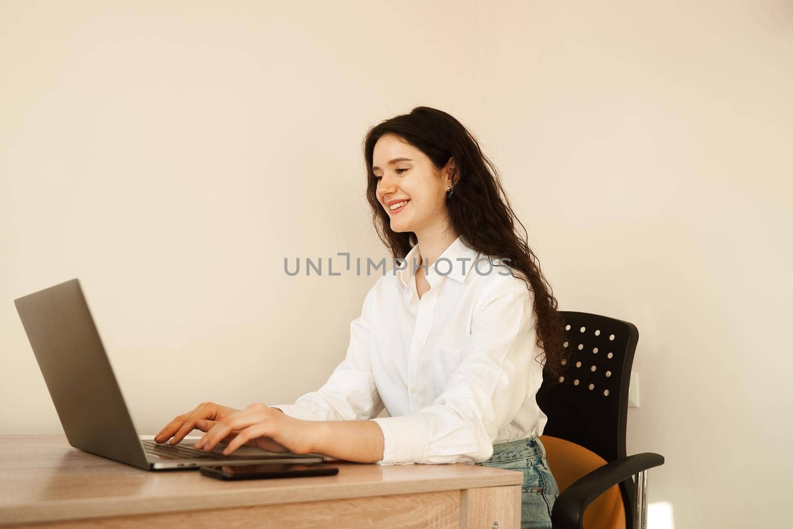 Business woman with laptop working online at freelance work. Attractive girl watching online video tutorial about designer work. by Rabizo