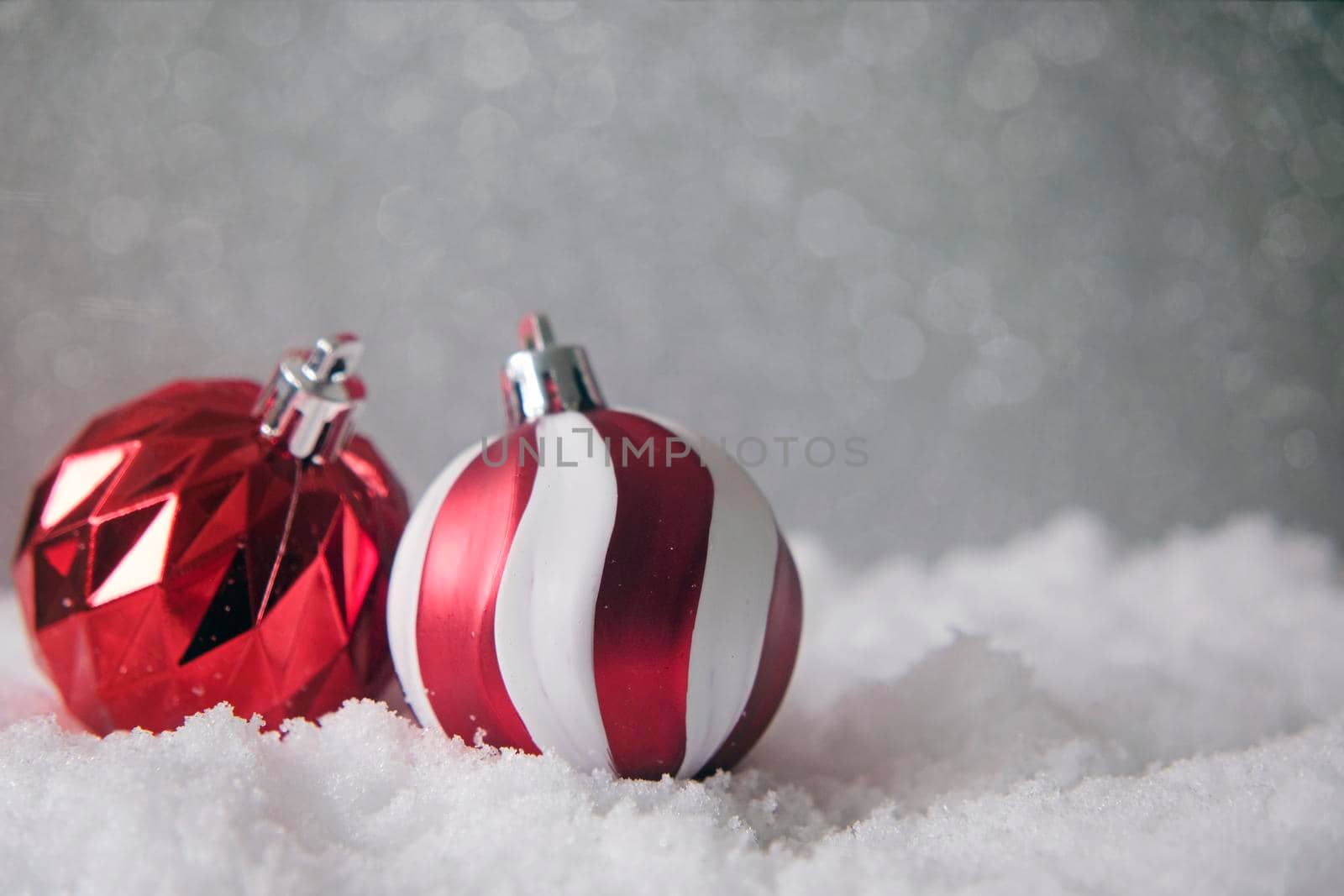 christmas tree decoration, white and red balls, on snow on glitter background. Christmas greeting card