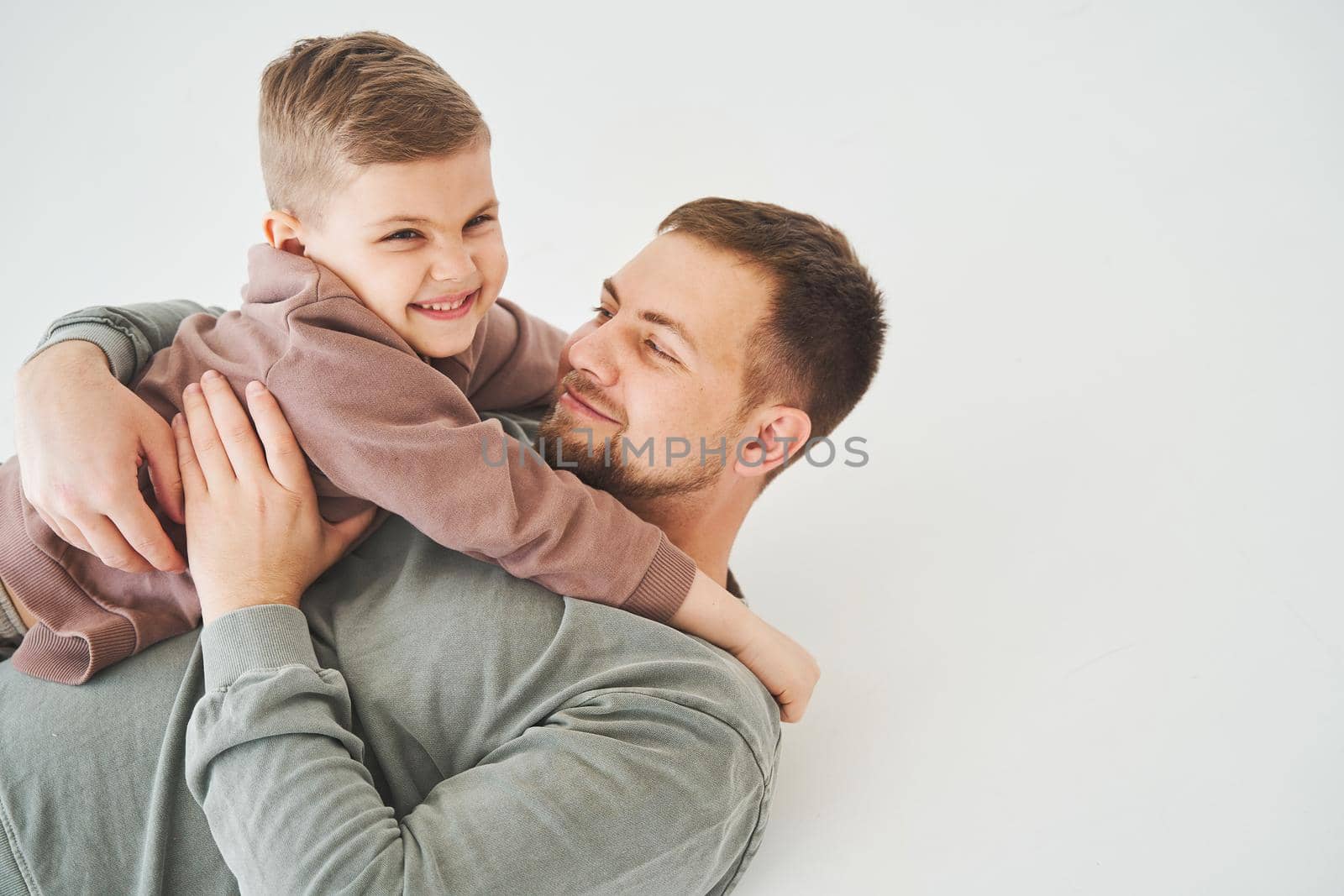 Close-up portrait of smiling father and son. Handsome dad and cheerful and emotional kid. Paternity