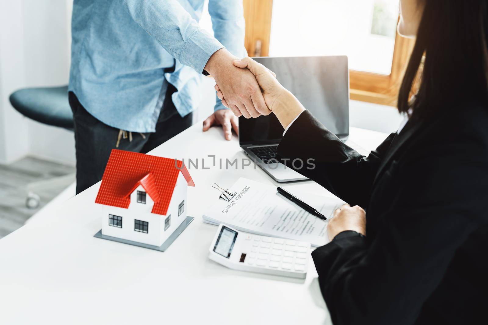 Laws, contracts, mortgages, clients join hands with real estate agents congratulating real estate agents on home and land purchase agreements with insurance to reduce risks during home installments by Manastrong