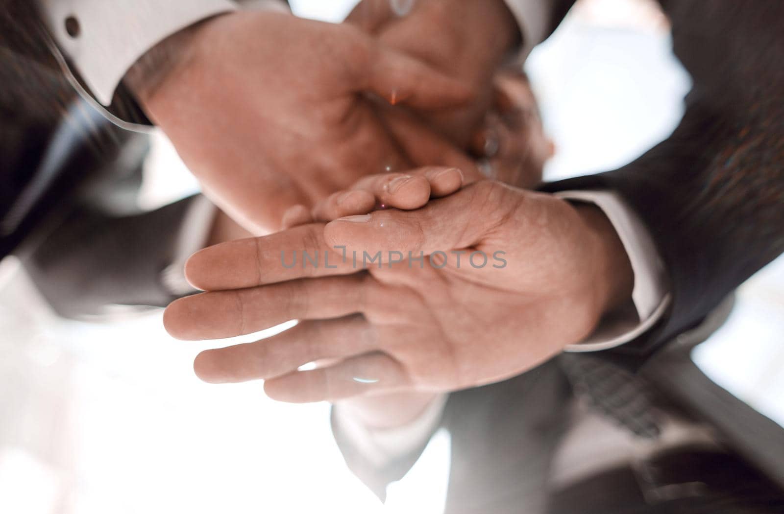 close up.business colleagues folded a stack of their hands.the concept of teamwork