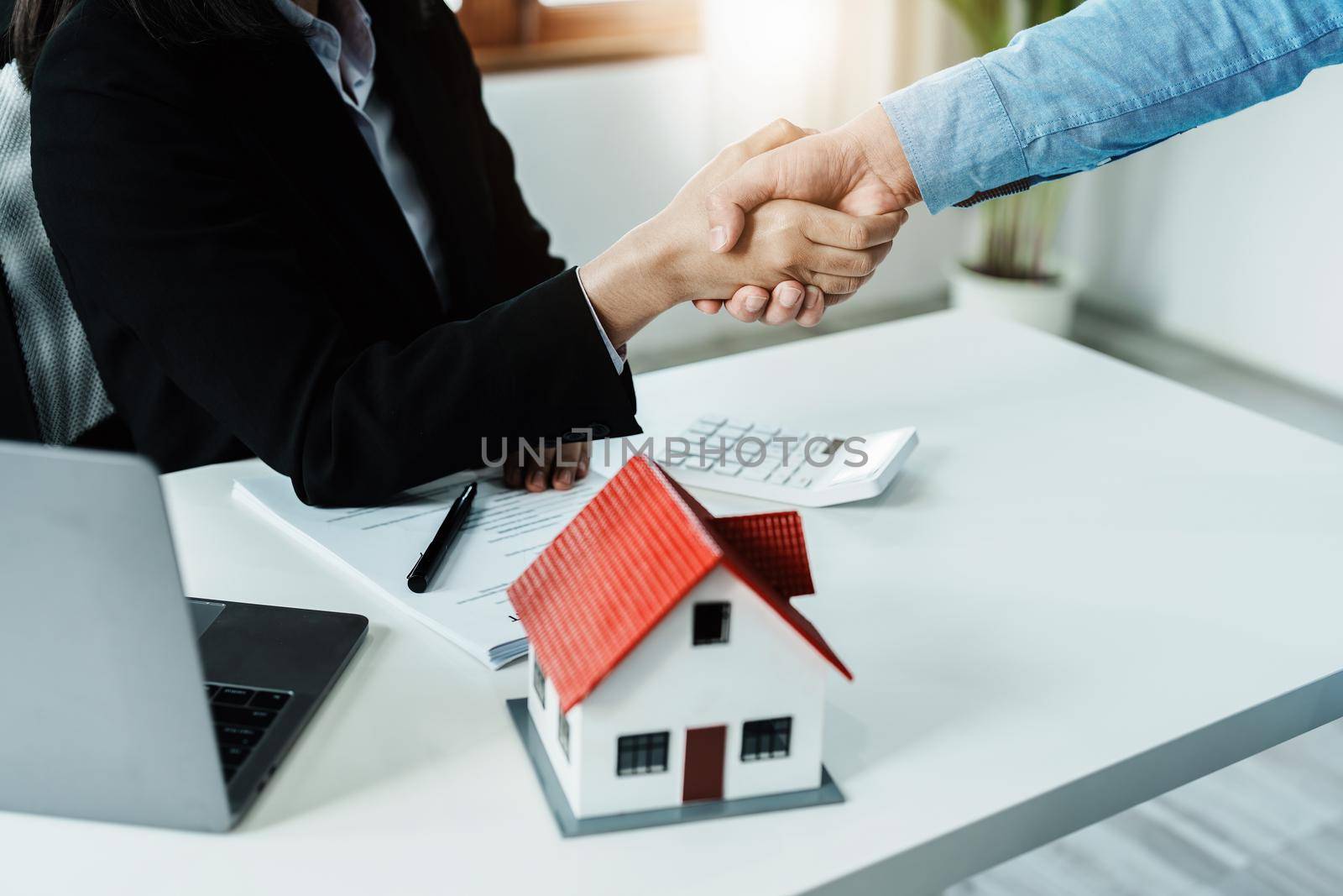 Laws, contracts, mortgages, clients join hands with real estate agents congratulating real estate agents on home and land purchase agreements with insurance to reduce risks during home installments.